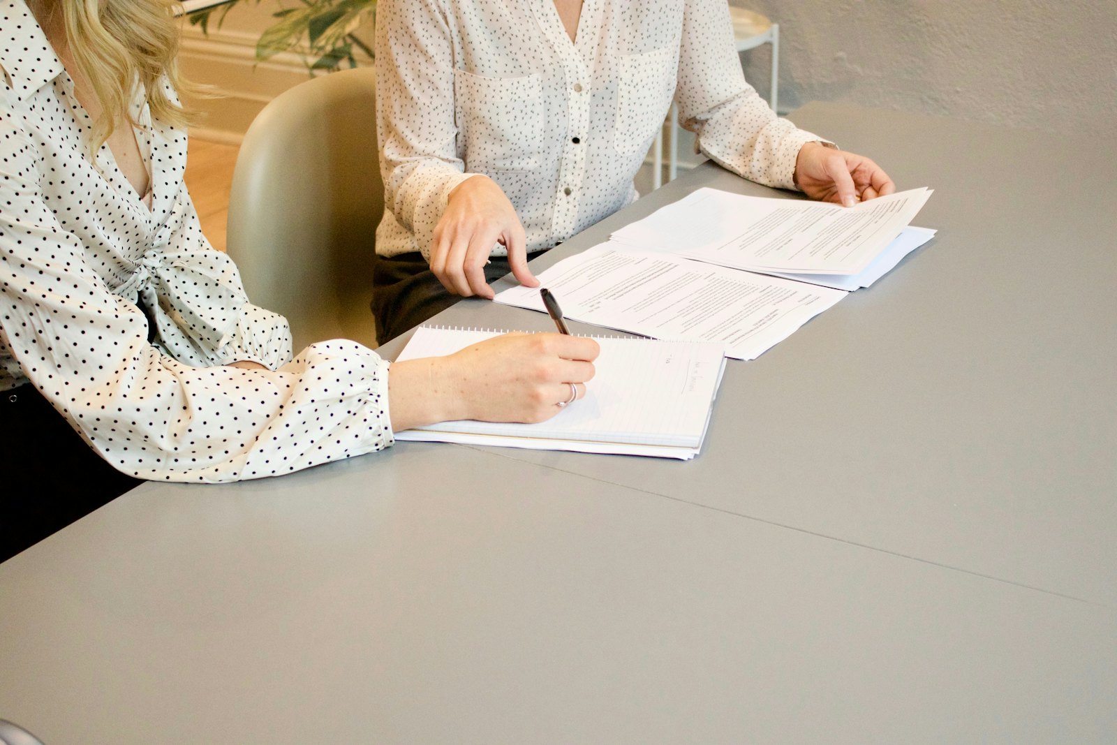 Two people reviewing printed documents at a desk